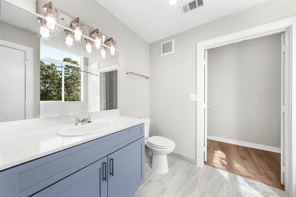 3522 Main Street, Unit 212 Rowlett, TX 75088 - Photo 13 of 25 a bathroom with a sink a toilet a mirror and shower