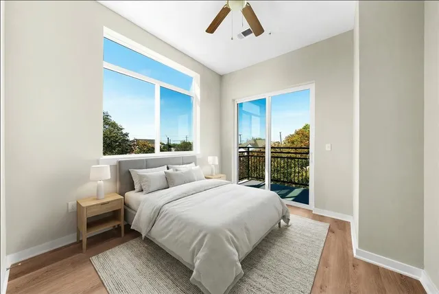 a kitchen with stainless steel appliances kitchen island granite countertop a sink dishwasher stove and white cabinets with wooden floor