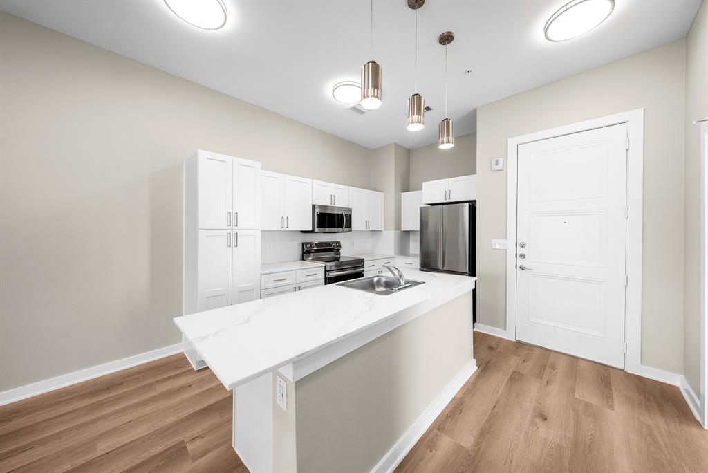 3522 Main Street, Unit 212 Rowlett, TX 75088 - Photo 4 of 25 a kitchen with a sink a counter top space stainless steel appliances and cabinets