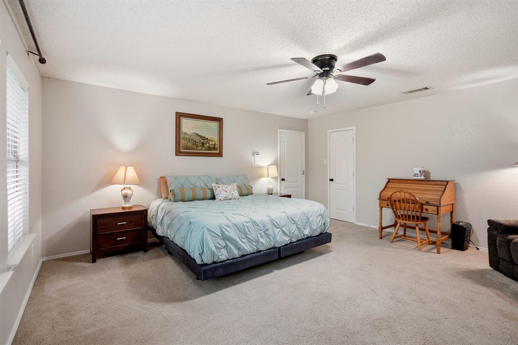 1213 Hampton Drive Forney, TX 75126 - Photo 16 of 27 a bedroom with a bed and a chandelier