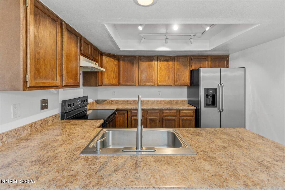 1090 Hartford Court Reno, NV 89503 - Photo 15 of 45 a kitchen with stainless steel appliances granite countertop a refrigerator a stove and a sink with wooden cabinets