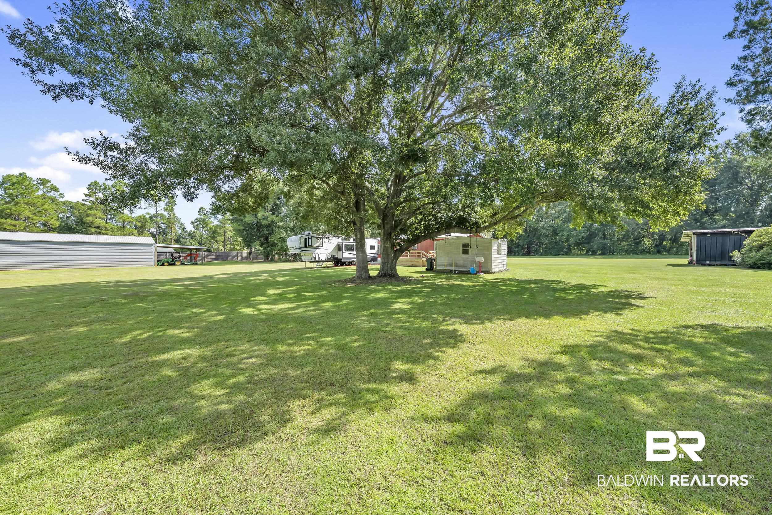 22823 Lanier Road Robertsdale, AL 36567 - Photo 22 of 46 View of green lawn with a storage unit