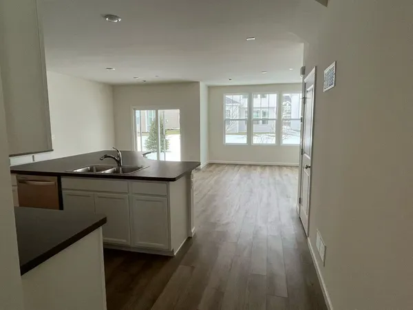 a kitchen with granite countertop a stove a sink and wooden floor
