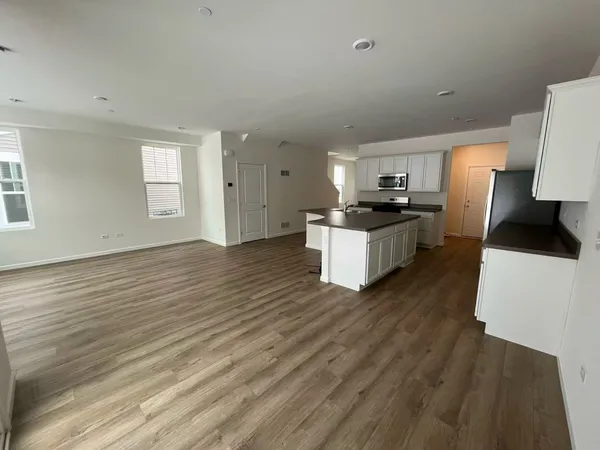 a kitchen with a sink and wooden floor