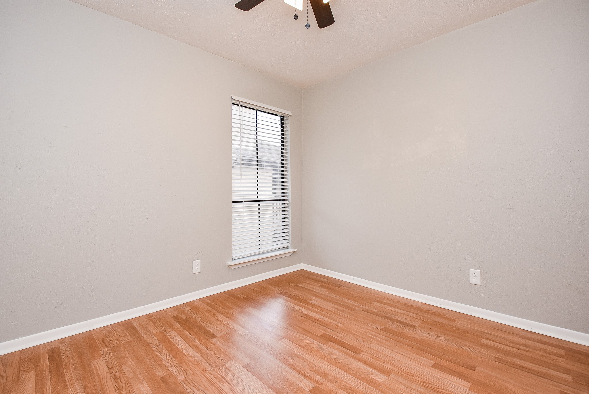 5000 Milwee Street, Unit 74 Houston, TX 77092 - Photo 29 of 35 an empty room with wooden floor chandelier fan and windows