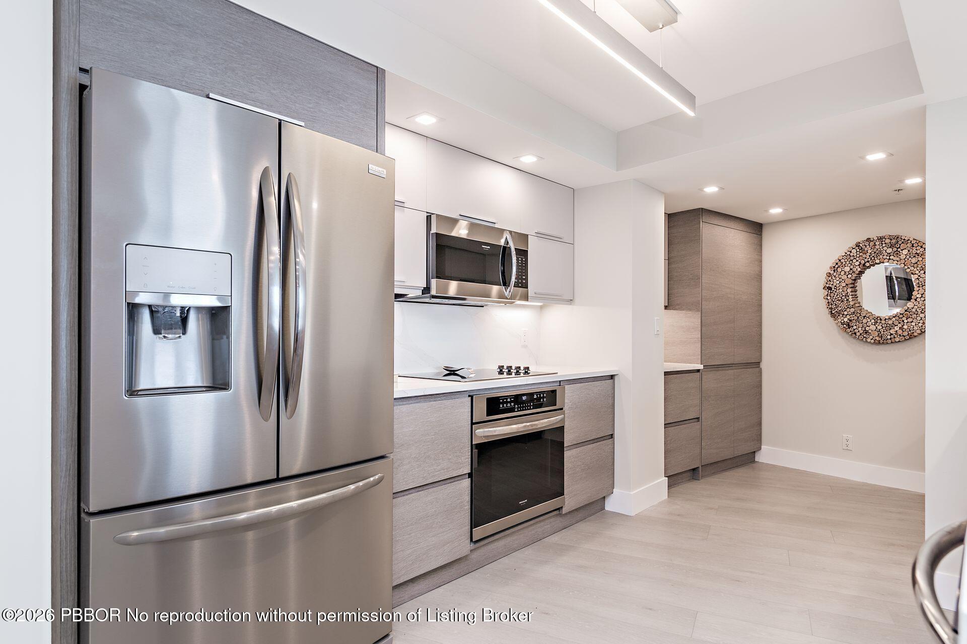 3000 North Ocean Drive, Unit 32E Riviera Beach, FL 33404 - Photo 22 of 36 a kitchen with stainless steel appliances granite countertop a refrigerator a stove a sink and a microwave