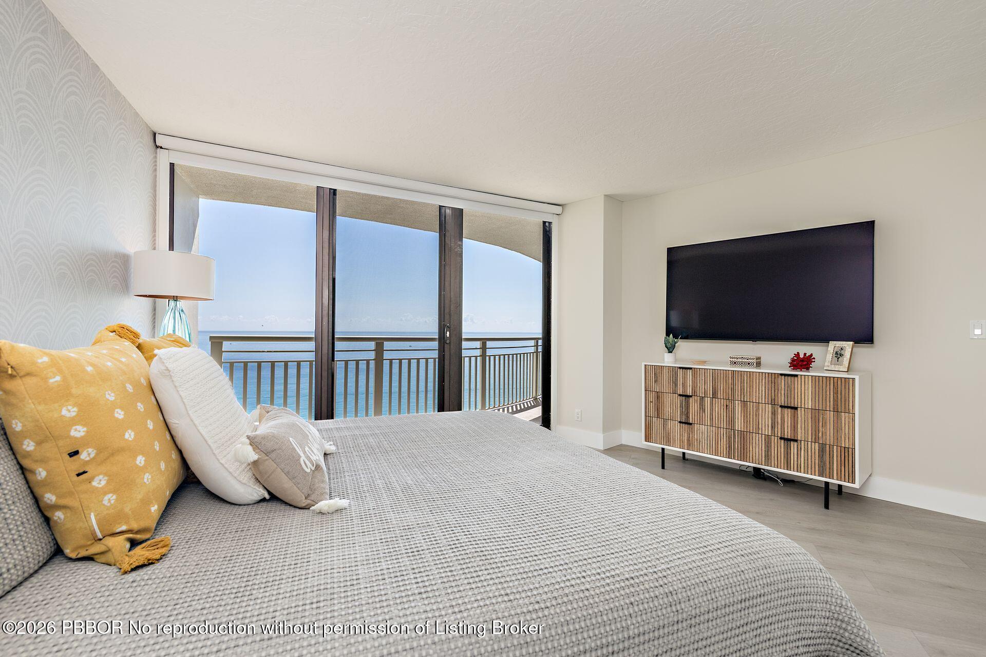 3000 North Ocean Drive, Unit 32E Riviera Beach, FL 33404 - Photo 27 of 36 a bedroom with furniture and a flat screen tv