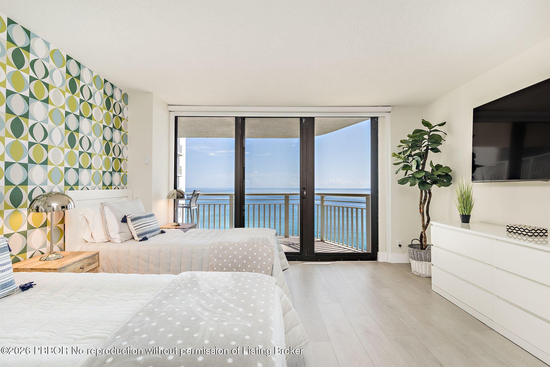 3000 North Ocean Drive, Unit 32E Riviera Beach, FL 33404 - Photo 29 of 36 a bedroom with a large bed and a flat tv screen on dresser