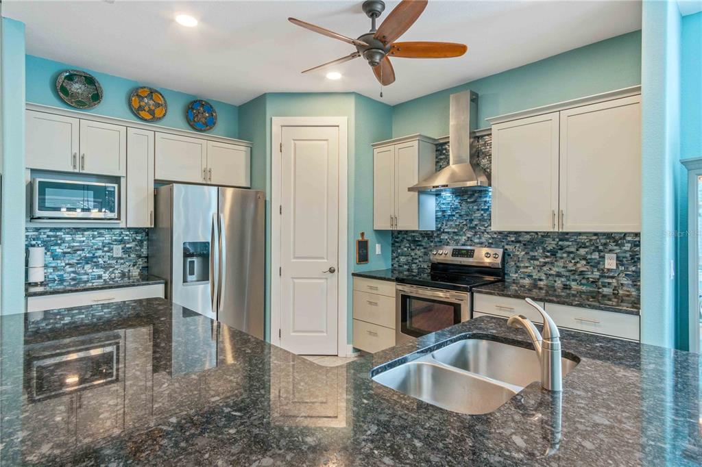 114 Venice Road Rotonda West, FL 33947 - Photo 25 of 88 a kitchen with stainless steel appliances granite countertop a sink a refrigerator and a granite counter tops