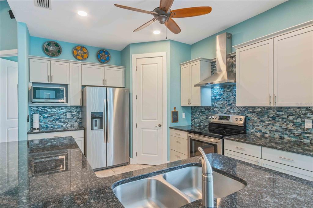114 Venice Road Rotonda West, FL 33947 - Photo 26 of 88 a kitchen with stainless steel appliances granite countertop a sink a stove and a refrigerator