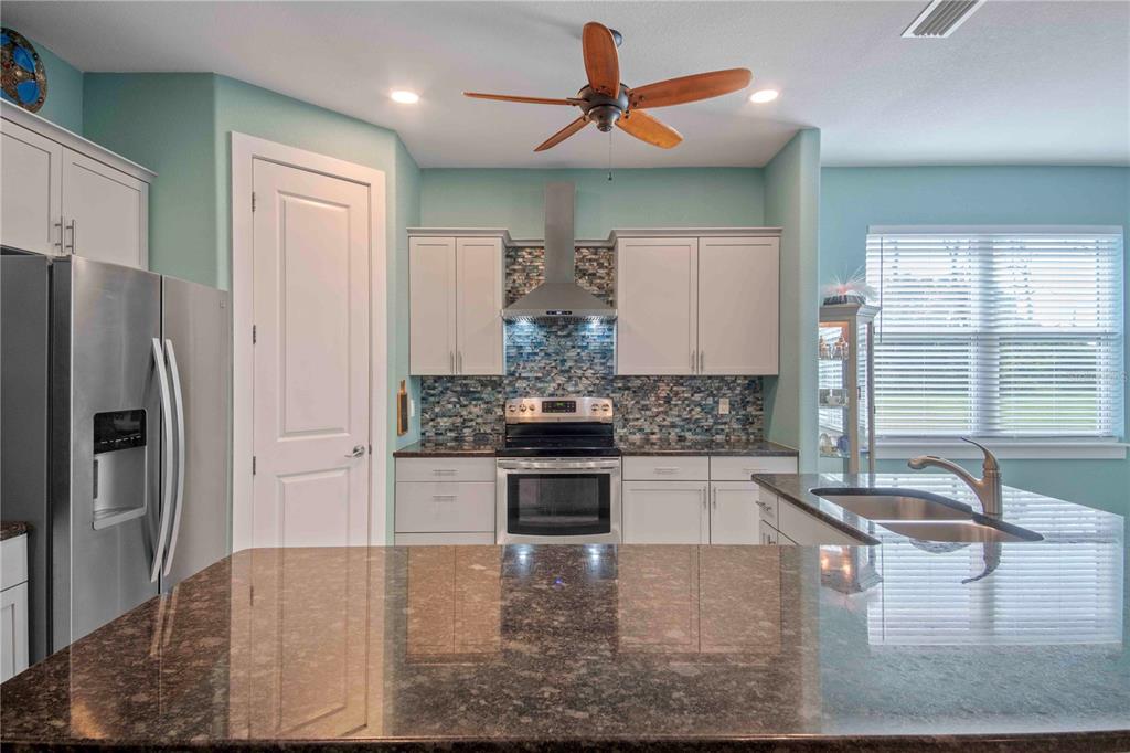 114 Venice Road Rotonda West, FL 33947 - Photo 27 of 88 a kitchen with kitchen island a counter top space a sink stainless steel appliances and cabinets