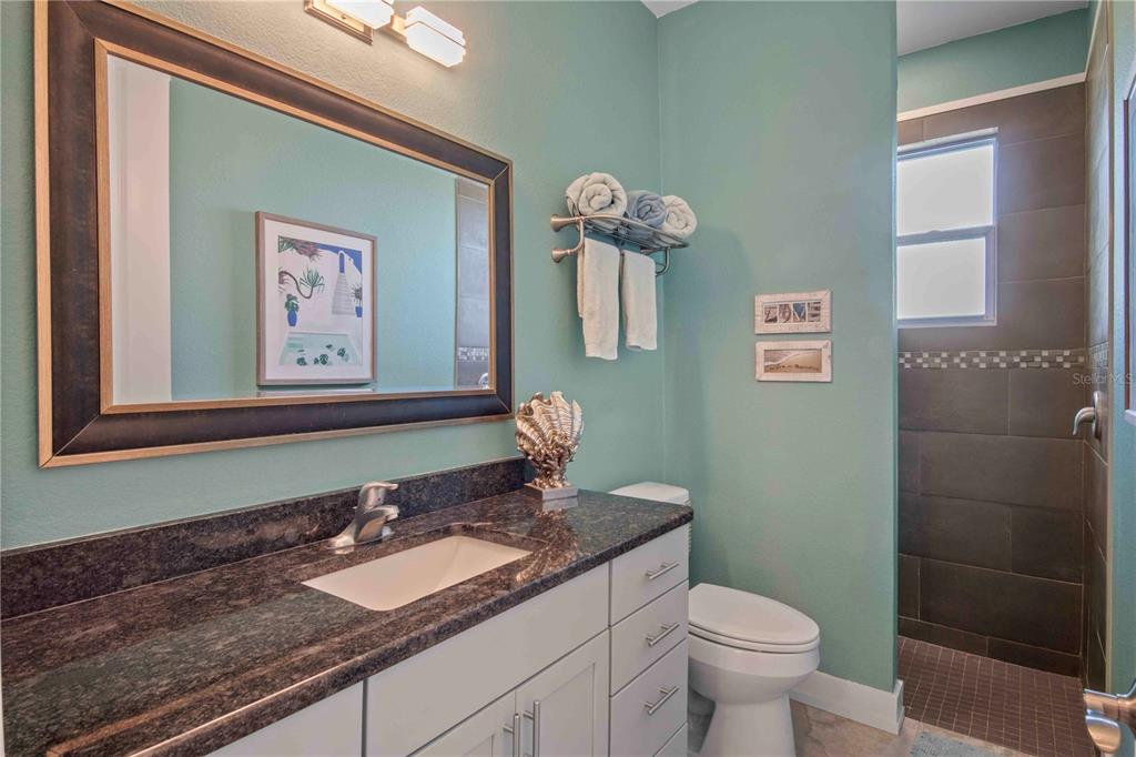 114 Venice Road Rotonda West, FL 33947 - Photo 77 of 88 a bathroom with a granite countertop sink mirror vanity and toilet