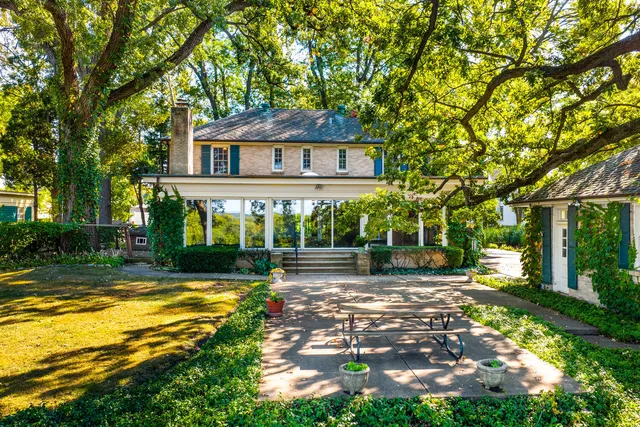 a view of a house with a big yard and large trees