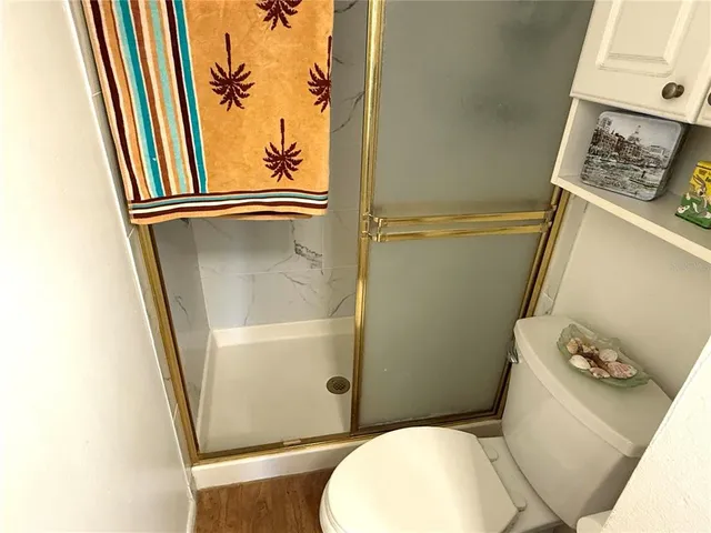 a white toilet sitting next to a bathroom sink and a mirror
