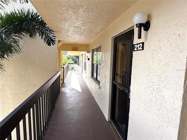 a view of a hallway with wooden floor and stairs
