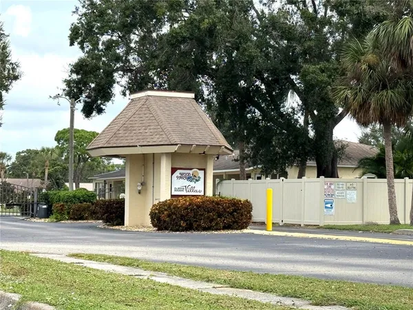 a view of a house with a yard and large tree
