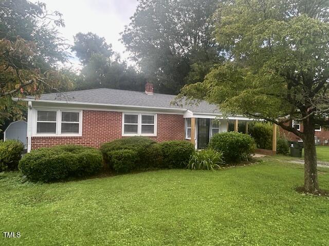 a view of a house next to a big yard and large trees