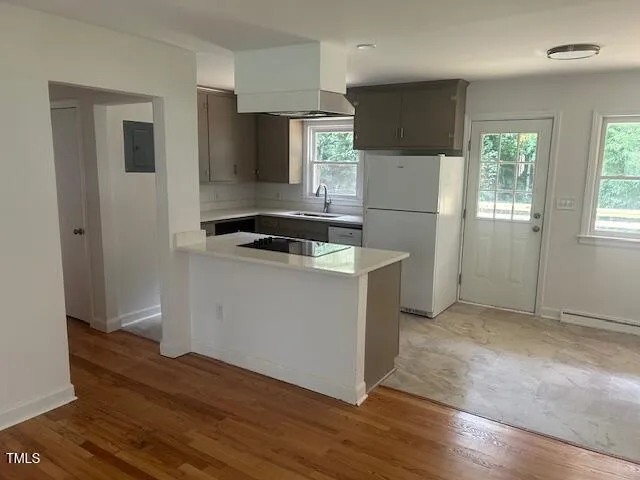 a kitchen with a refrigerator stove and wooden floor