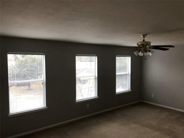 a view of a livingroom with a ceiling fan and window