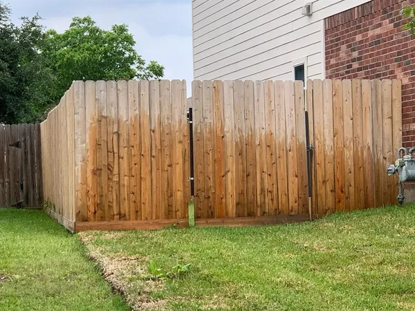 a view of a backyard with wooden fence