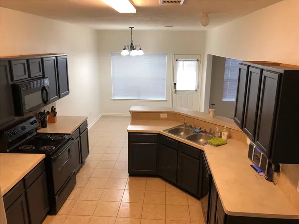 a kitchen with a stove sink and a refrigerator
