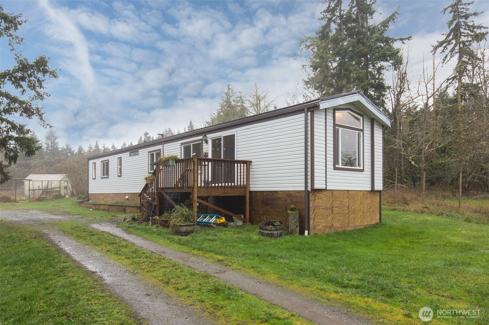 501 McCarver Road Port Angeles, WA 98362 - Photo 1 of 36 a backyard of a house with wooden fence and large trees