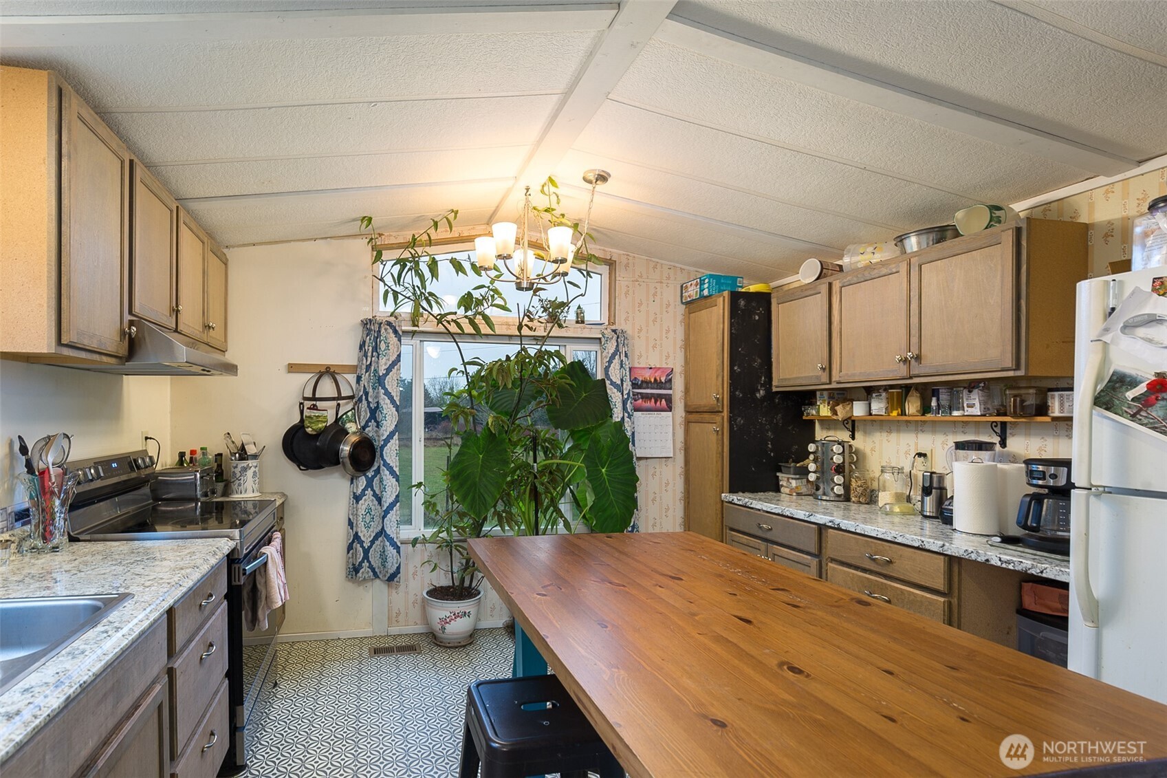 501 McCarver Road Port Angeles, WA 98362 - Photo 8 of 36 a kitchen with stainless steel appliances kitchen island granite countertop a refrigerator a stove a sink dishwasher and white cabinets with wooden floor