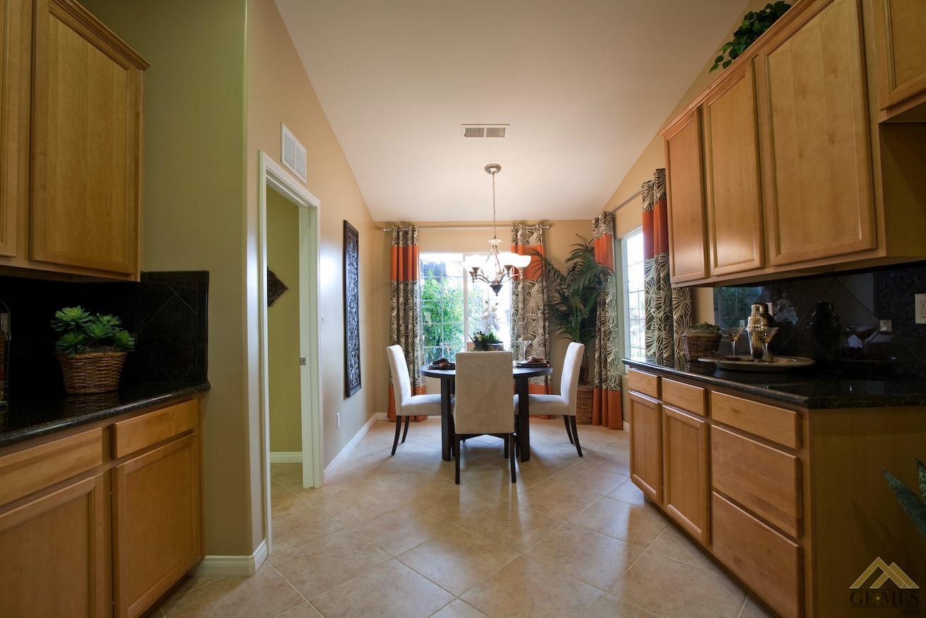a kitchen with stainless steel appliances granite countertop sink stove refrigerator and cabinets