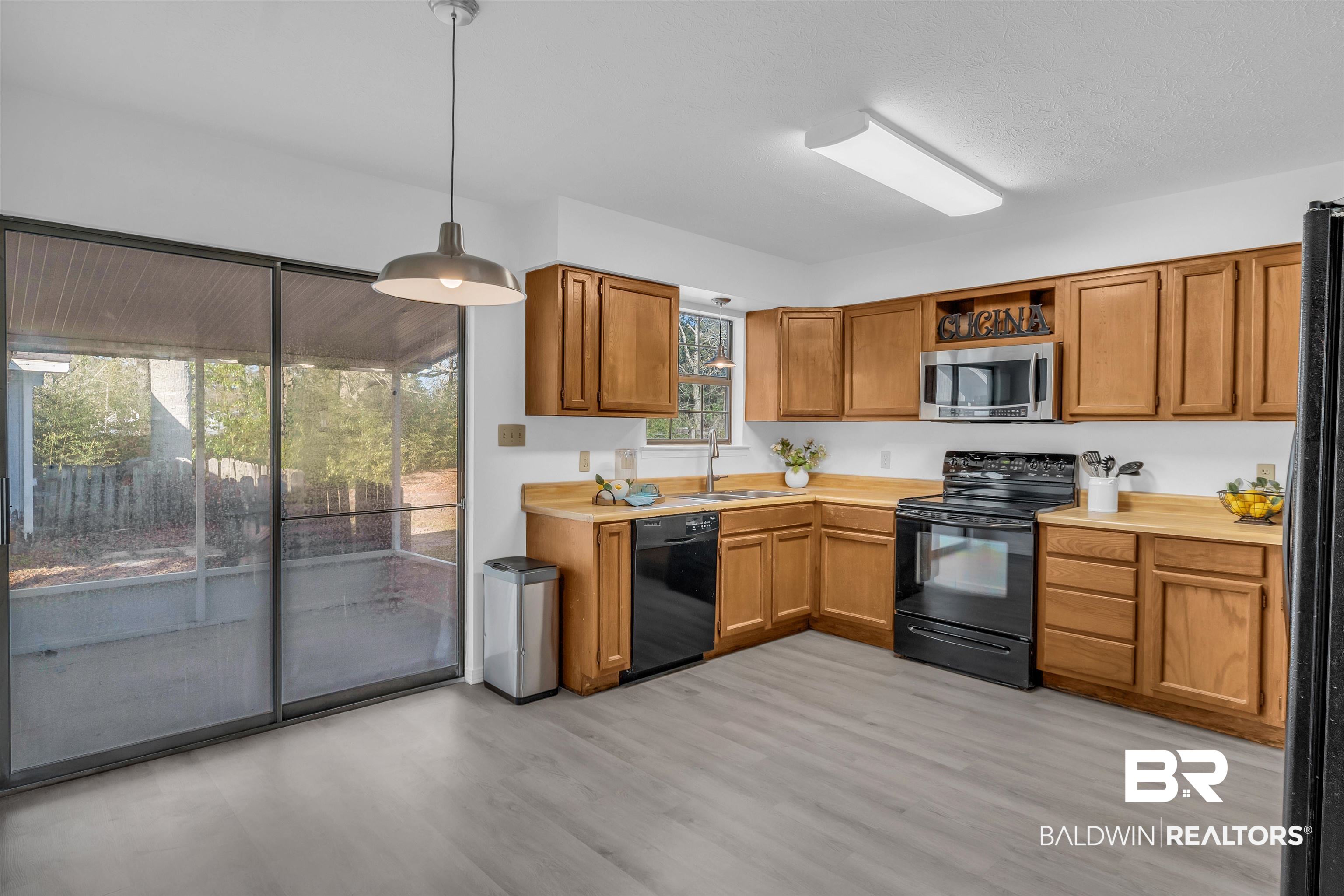 7 Verbena Circle Foley, AL 36535 - Photo 9 of 21 Kitchen featuring black appliances, pendant lighting, a sink, light wood-style floors, and light countertops
