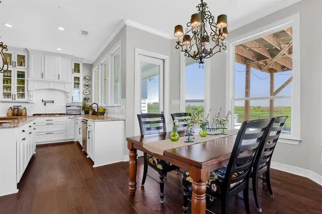 a view of a dining room with furniture a chandelier and wooden floor