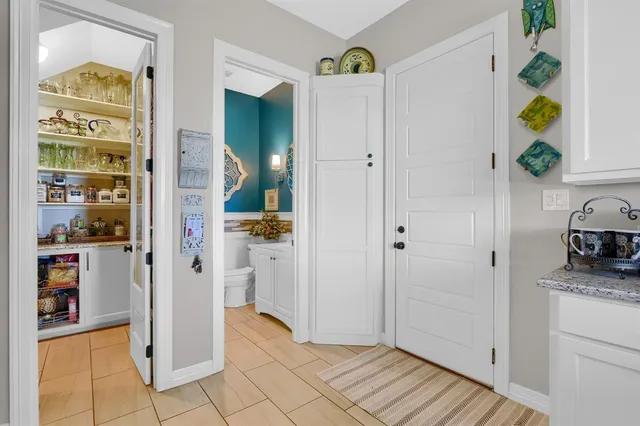 a view of a hallway with wooden floor and a living room