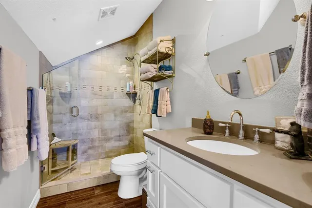 a bathroom with a granite countertop sink toilet and shower