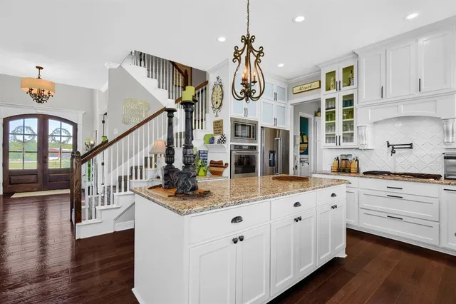 a open kitchen with white cabinets and chandelier