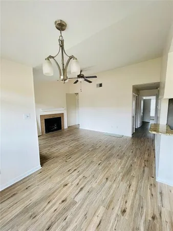 a view of empty room with wooden floor fireplace and window