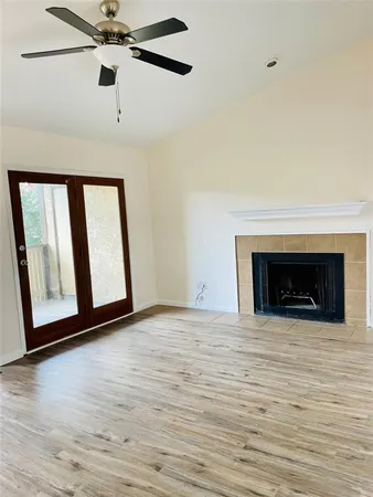 a view of an empty room with window and fireplace