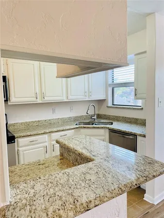 a kitchen with stainless steel appliances granite countertop a sink stove and cabinets