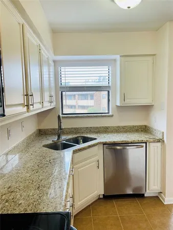 a kitchen with granite countertop a sink and a stove