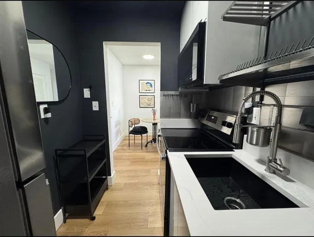 a kitchen with stainless steel appliances a stove a sink and a microwave