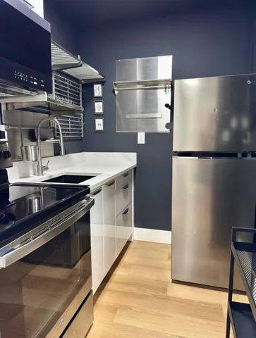 a kitchen with a refrigerator and a stove top oven