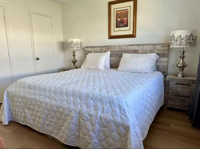 a bedroom with a bed and a painting on the wall