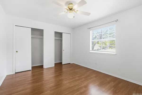 a view of an empty room with window and wooden floor