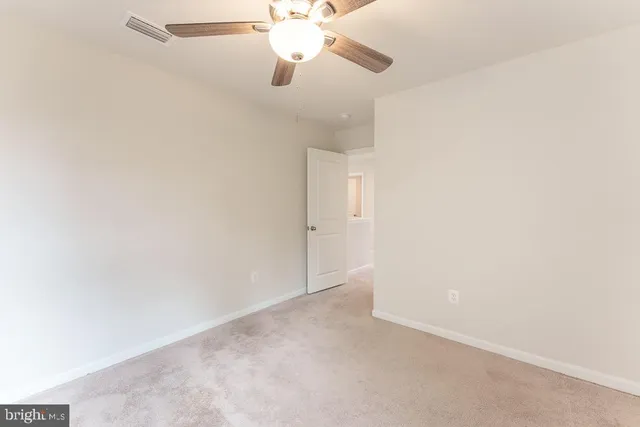an empty room with a fan and a fan