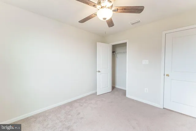 an empty room with a fan and a fan