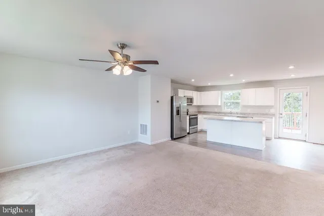 a view of an empty room with a kitchen