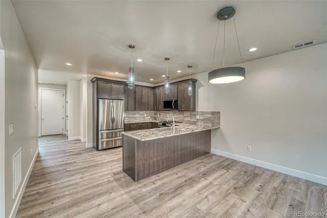 a view of kitchen with sink and refrigerator