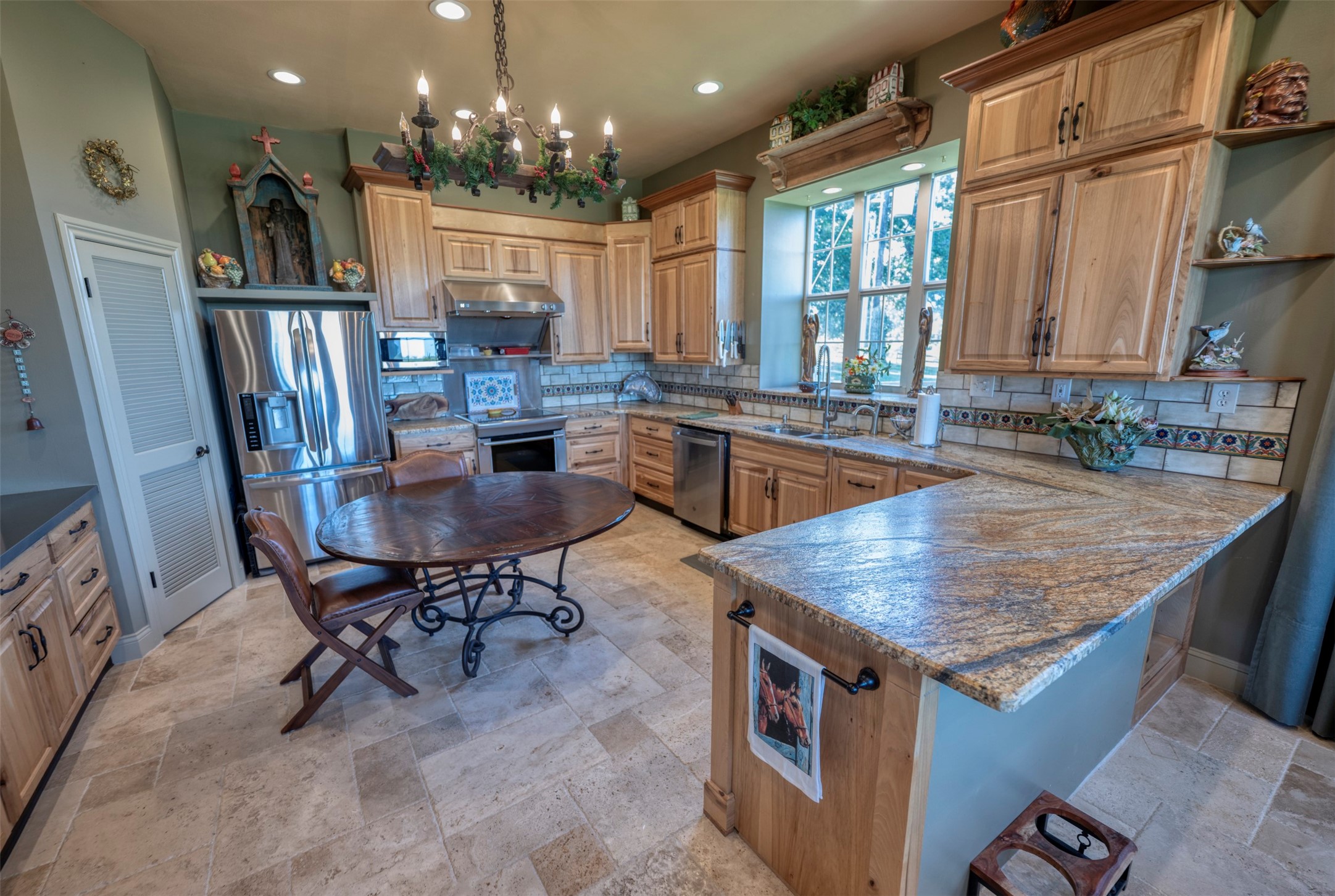 1711 Sempronius Road Chappell Hill, TX 77426 - Photo 36 of 50 a kitchen with kitchen island granite countertop a table chairs sink and cabinets