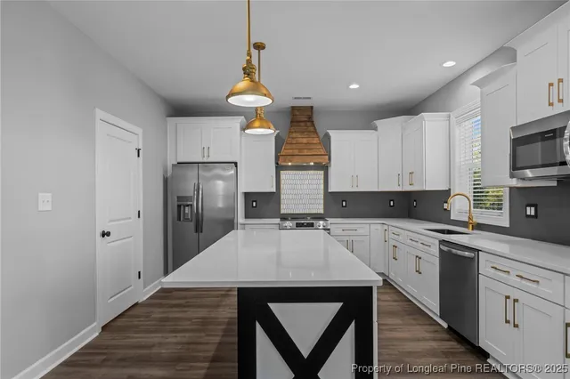 a kitchen with a sink a microwave a refrigerator and cabinets