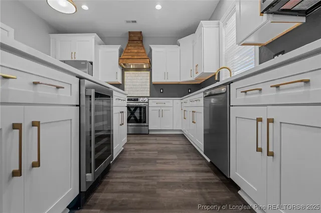 a kitchen with granite countertop a refrigerator and a stove top oven