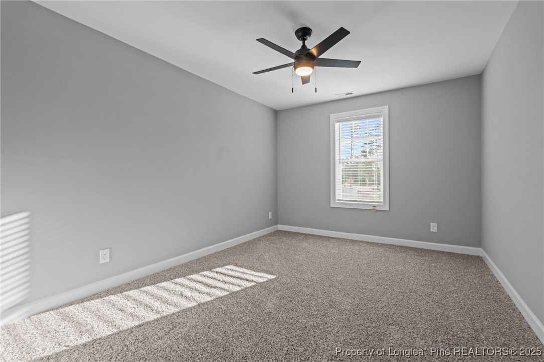 314 Persimmon Tree Drive Cameron, NC 28326 - Photo 23 of 46 an empty room with windows and a ceiling fan