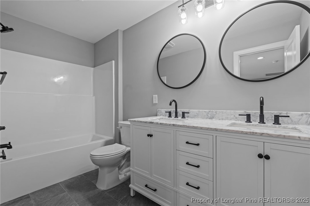 314 Persimmon Tree Drive Cameron, NC 28326 - Photo 24 of 46 a bathroom with a toilet a double vanity sink and a mirror